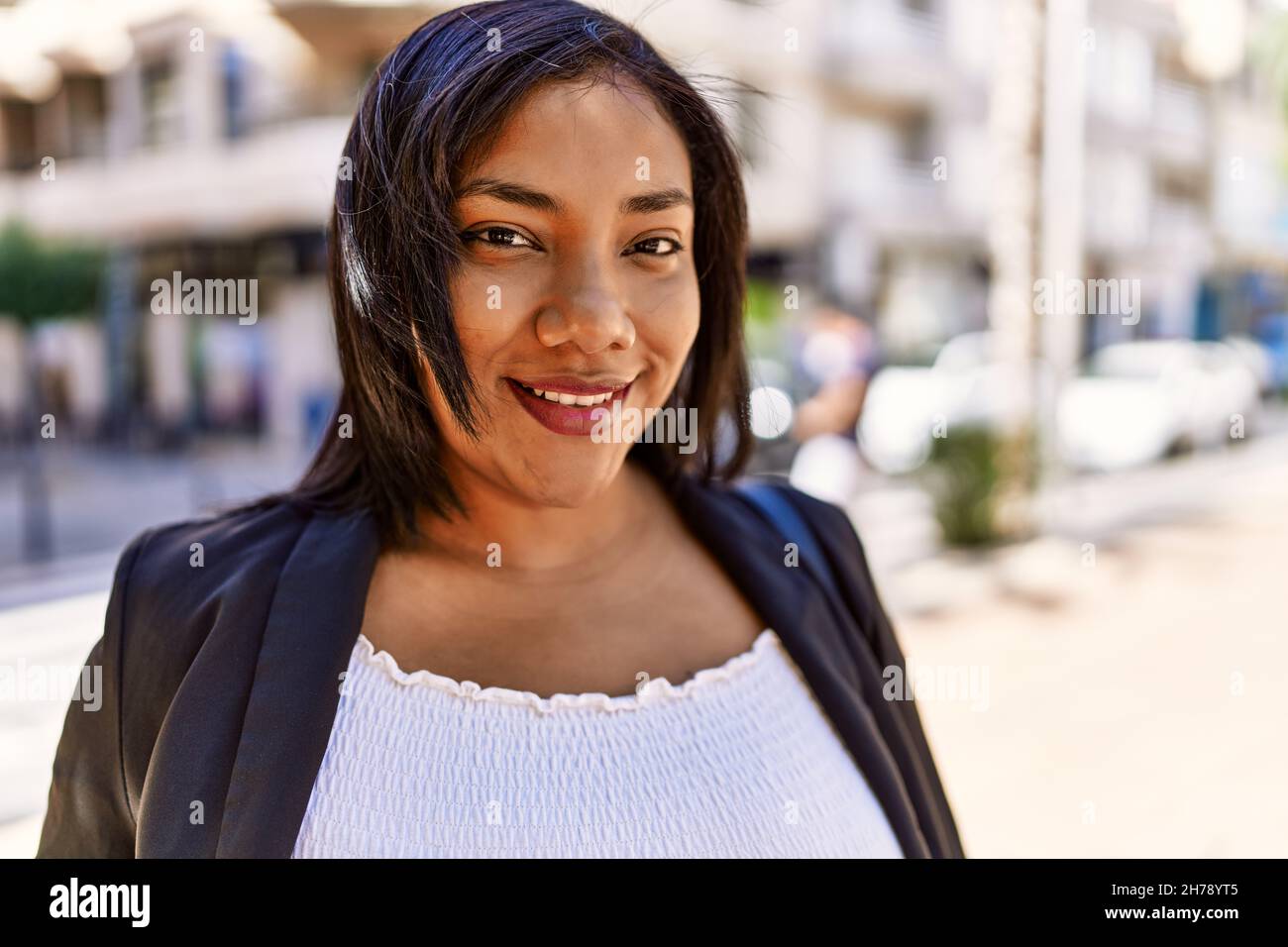 Beautiful hispanic woman smiling at the camera, walking outdoors on a ...