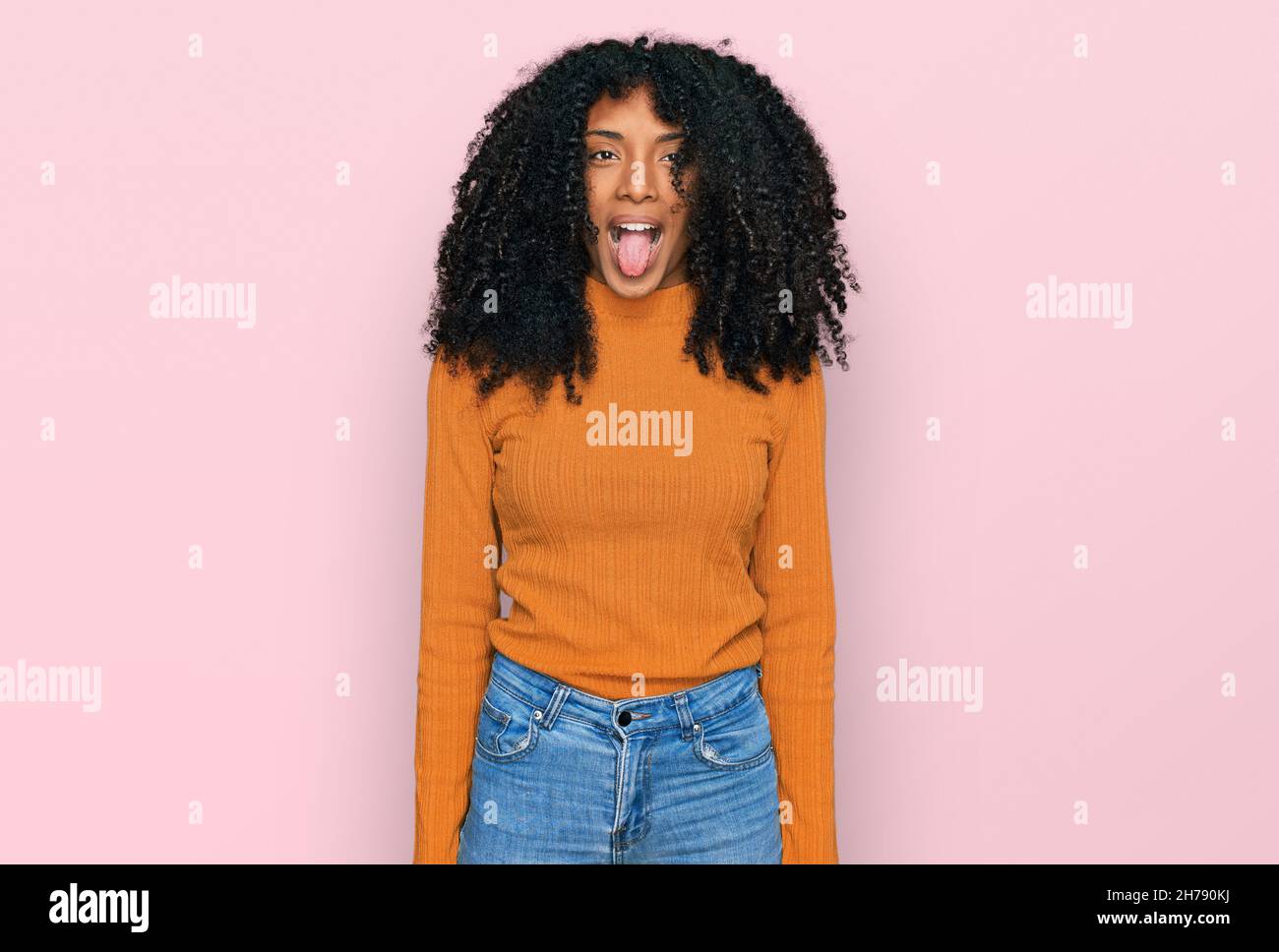 Young african american girl wearing casual clothes sticking tongue out ...