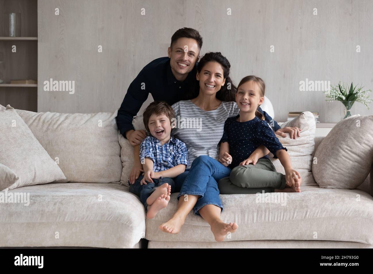 Happy beautiful couple with little children posing for photo Stock Photo