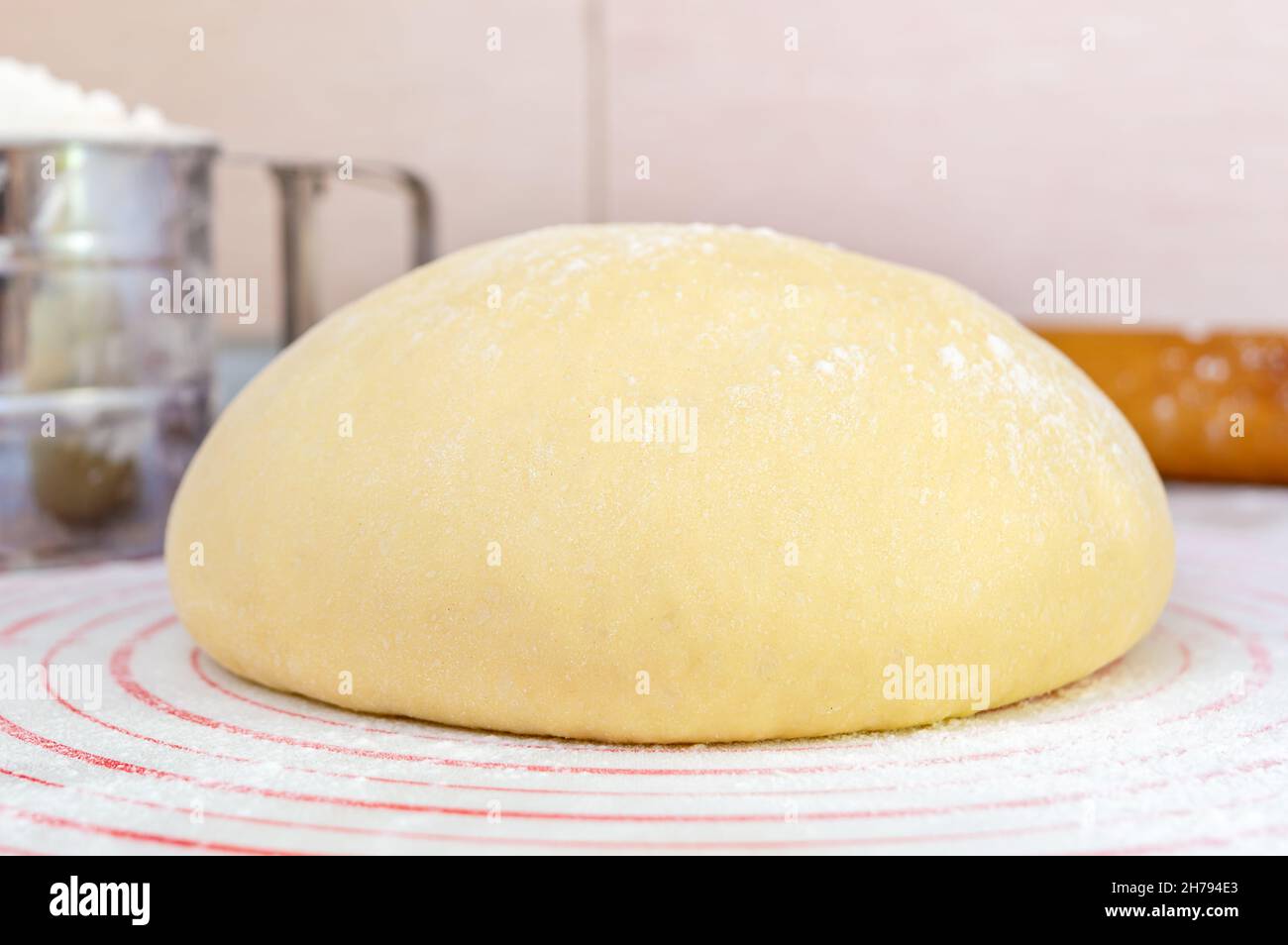Raw yeast dough on a special silicone baking mat for rolling dough on the kitchen table. Preparation of dough for pizza, pie, baking and other bakery Stock Photo