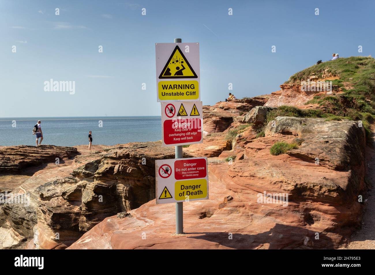 West Kirby, UK: Sign warning of unstable rock on cliff edge, Hilbre island on the Deeside estuary, Wirral peninsula. Stock Photo