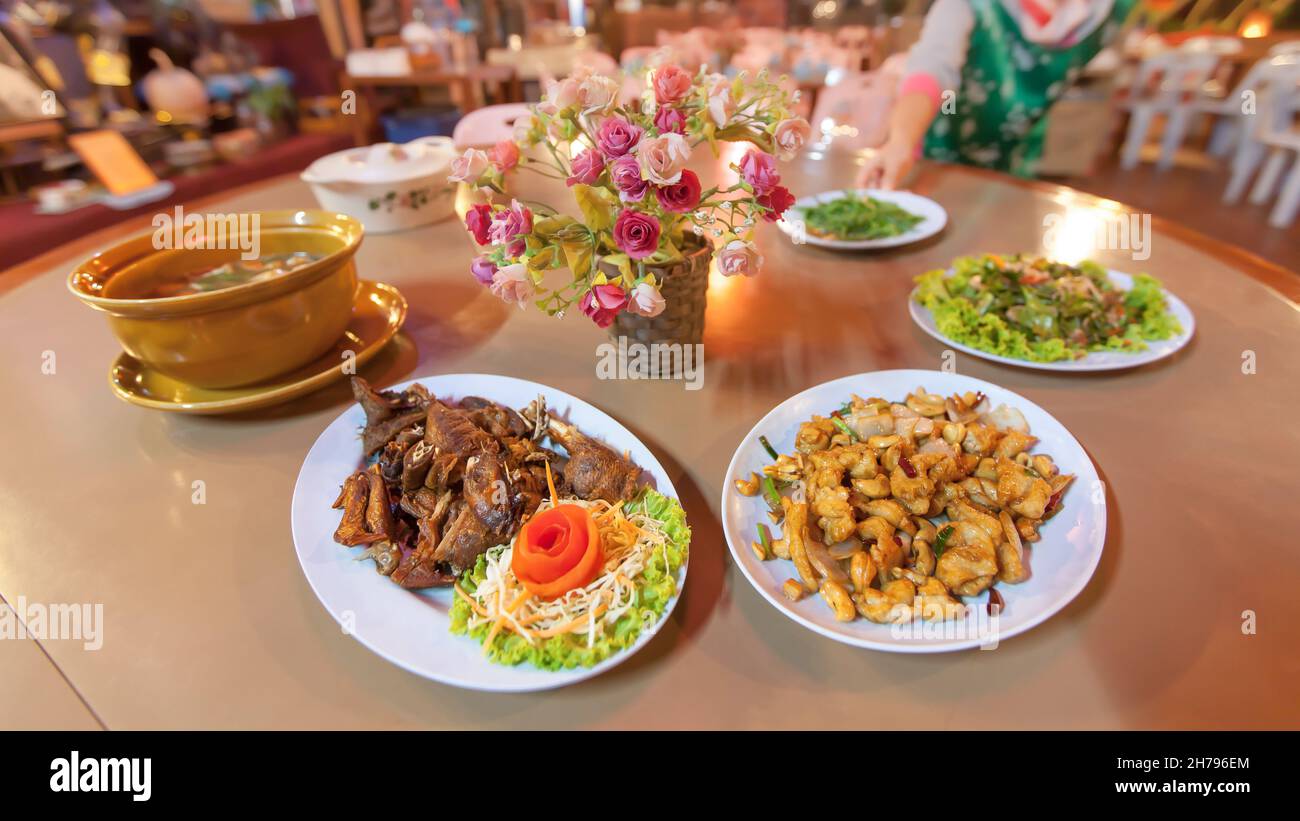 Traditional Yunnan-Chinese cuisine set, roasted chicken with sauce and salad, stir fried Chicken and cashew nut, mild soup and tea leaf salad. Stock Photo