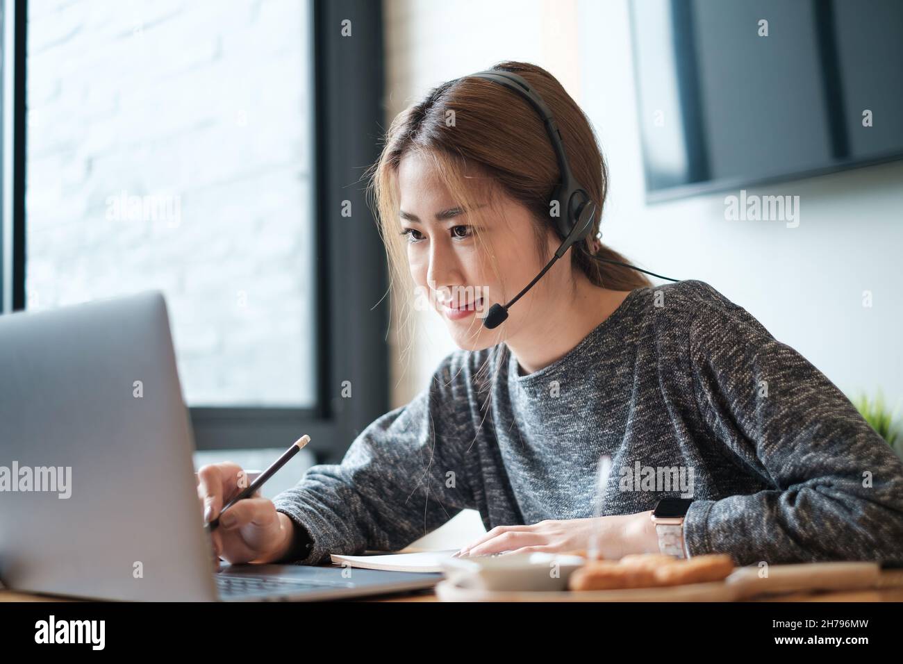 Customer service representative with a headset and work at home. business support team concept. Stock Photo