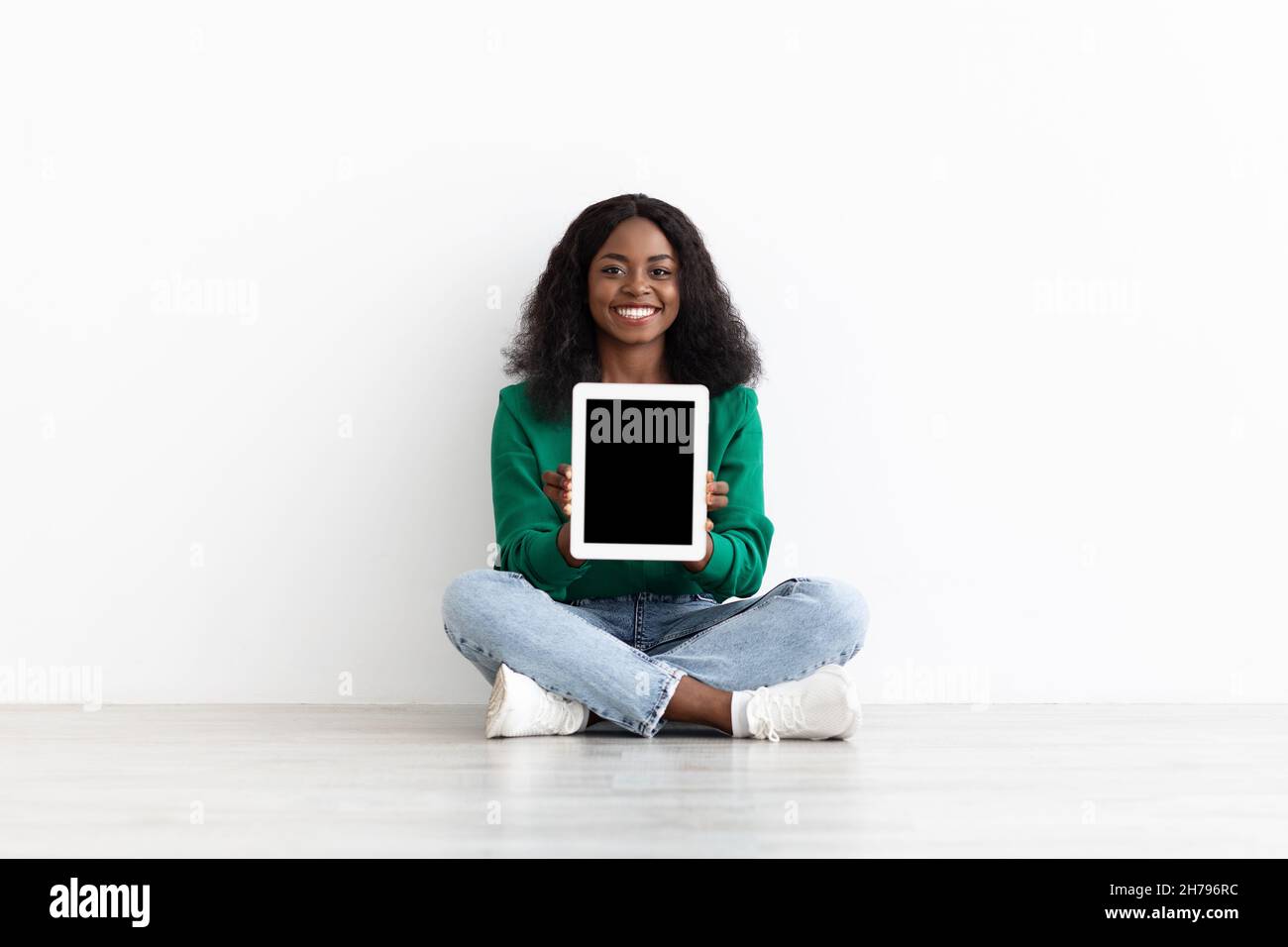 Emotional black woman showing modern digital tablet with empty screen ...