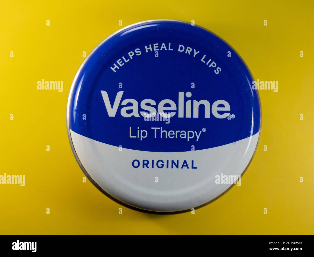 Tin of vaseline lip ointment on a yellow background Stock Photo