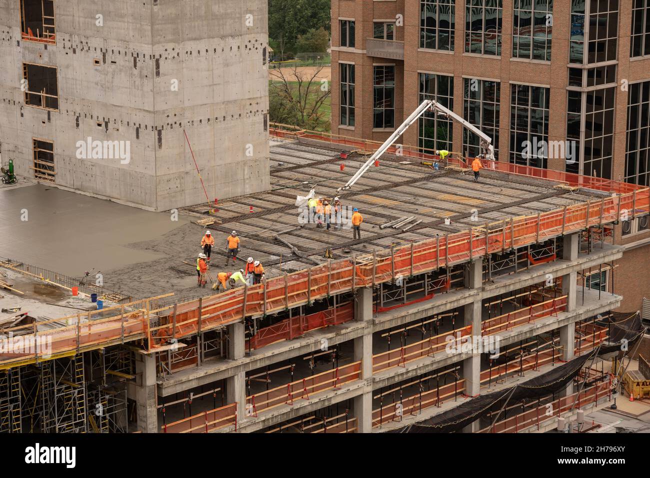 A construction crew pours concrete on a business district job site. The