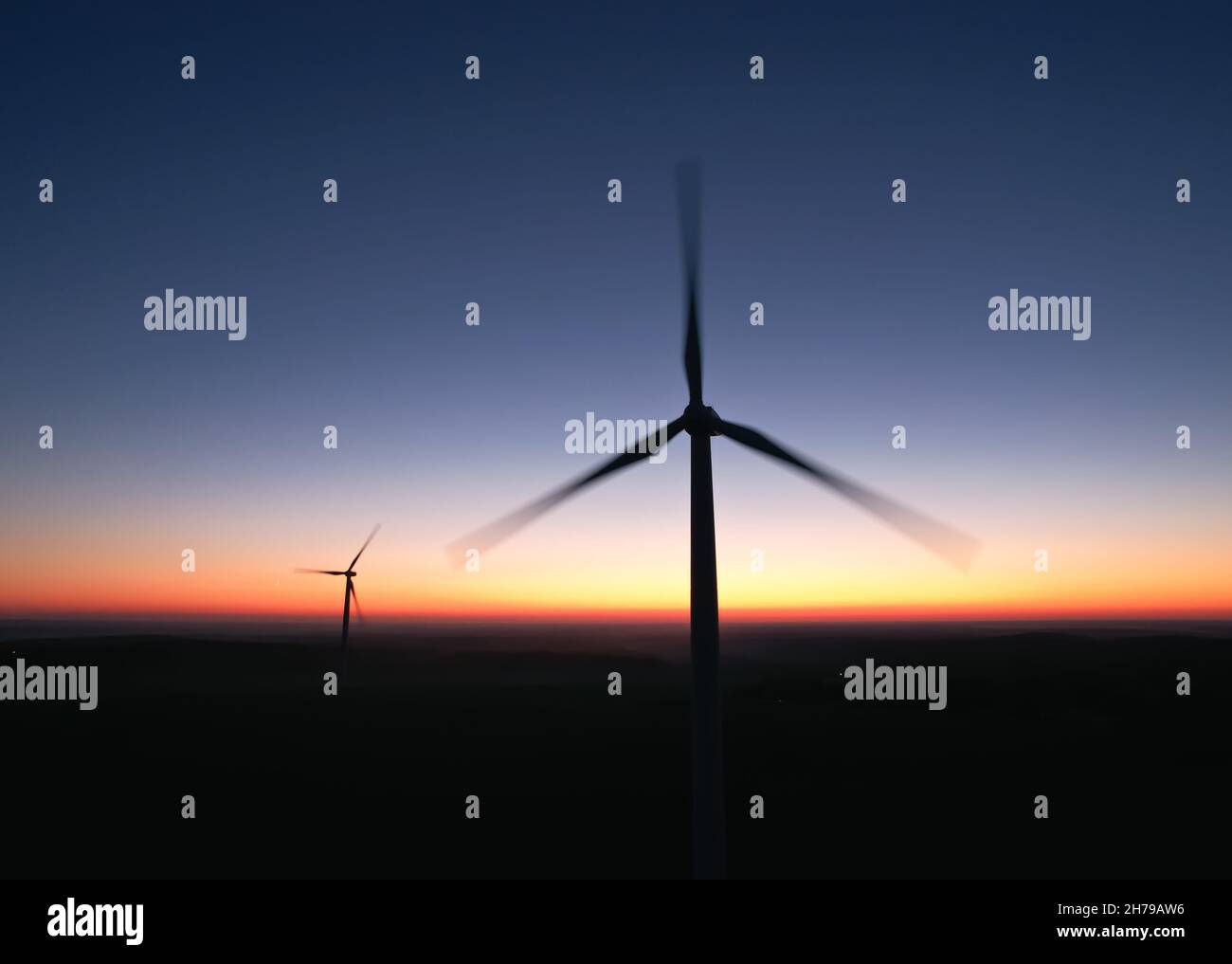 Two rotating propellers of wind turbines on the background of the night sky. Stock Photo