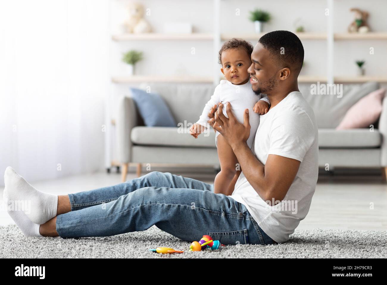 Bonding With Baby. Black Man Playing With His Infant Child At Home Stock Photo