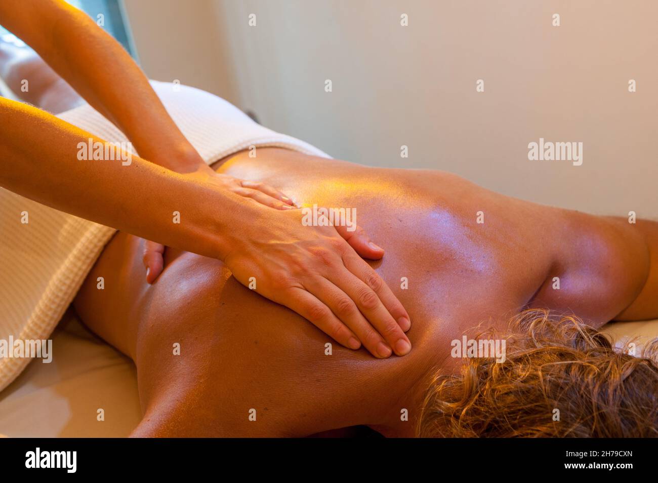 Back massage, hands of masseuse massaging shoulder of man in beauty spa salon Stock Photo