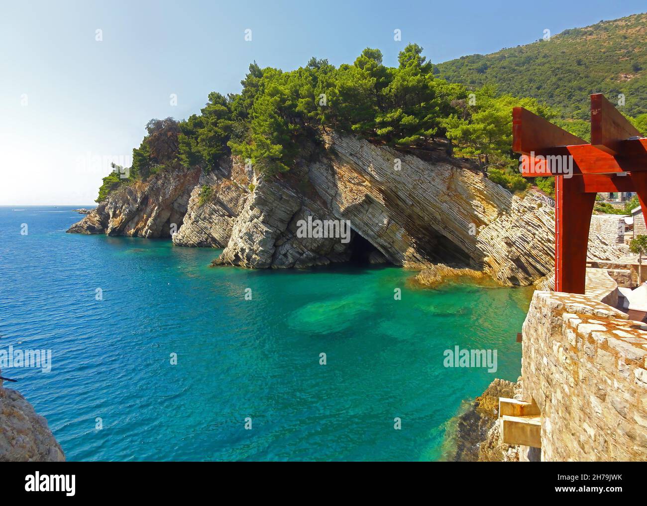 A landscape of cliffs covered in greenery surrounded by the sea in ...