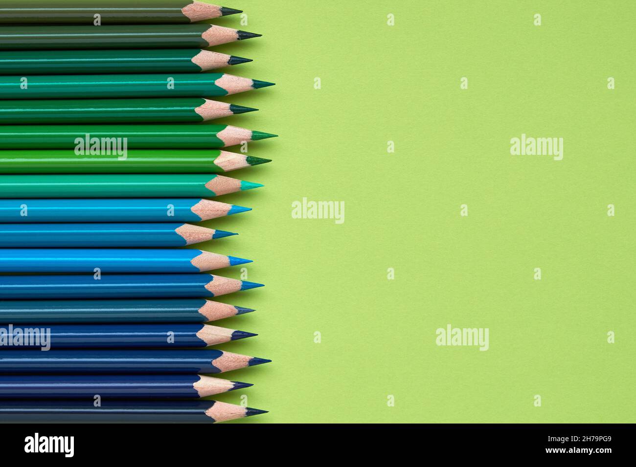 Colorful crayons in a row on light green background Stock Photo Alamy