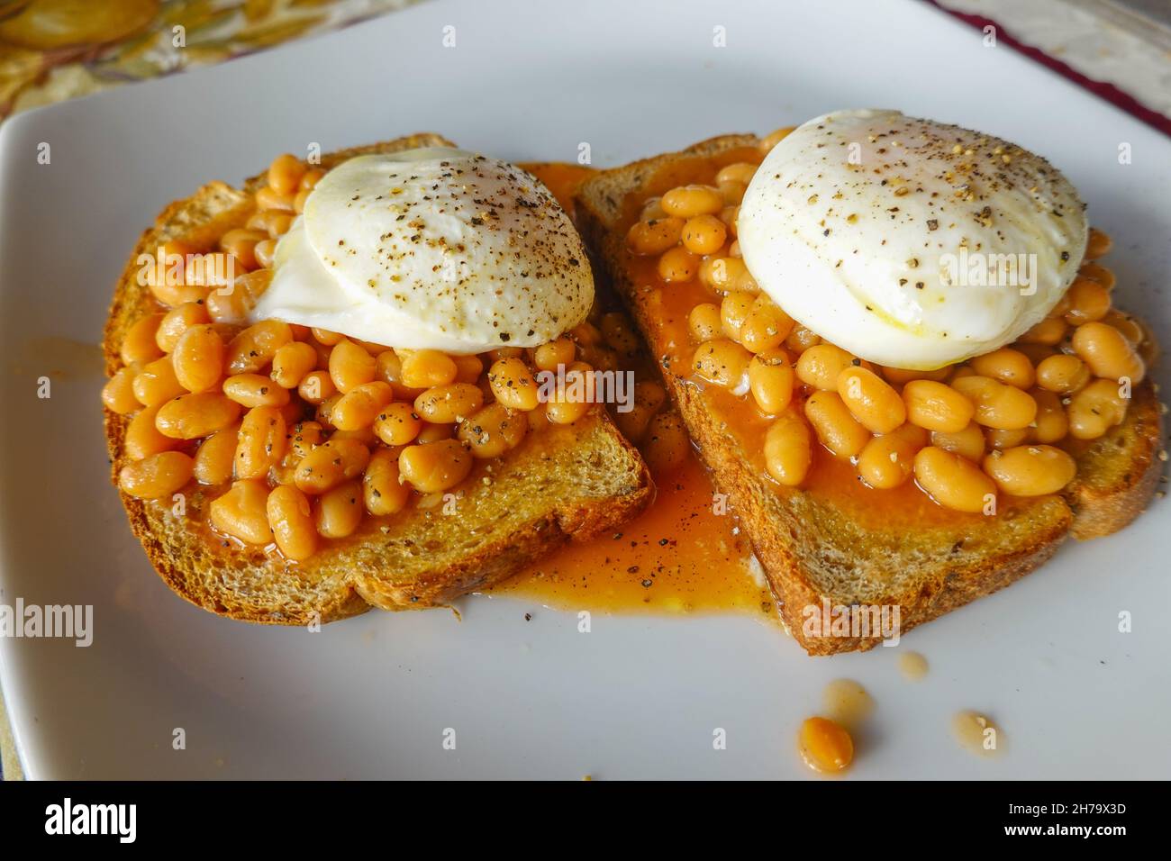 British family breakfast of poached eggs on top of baked beans on toast
