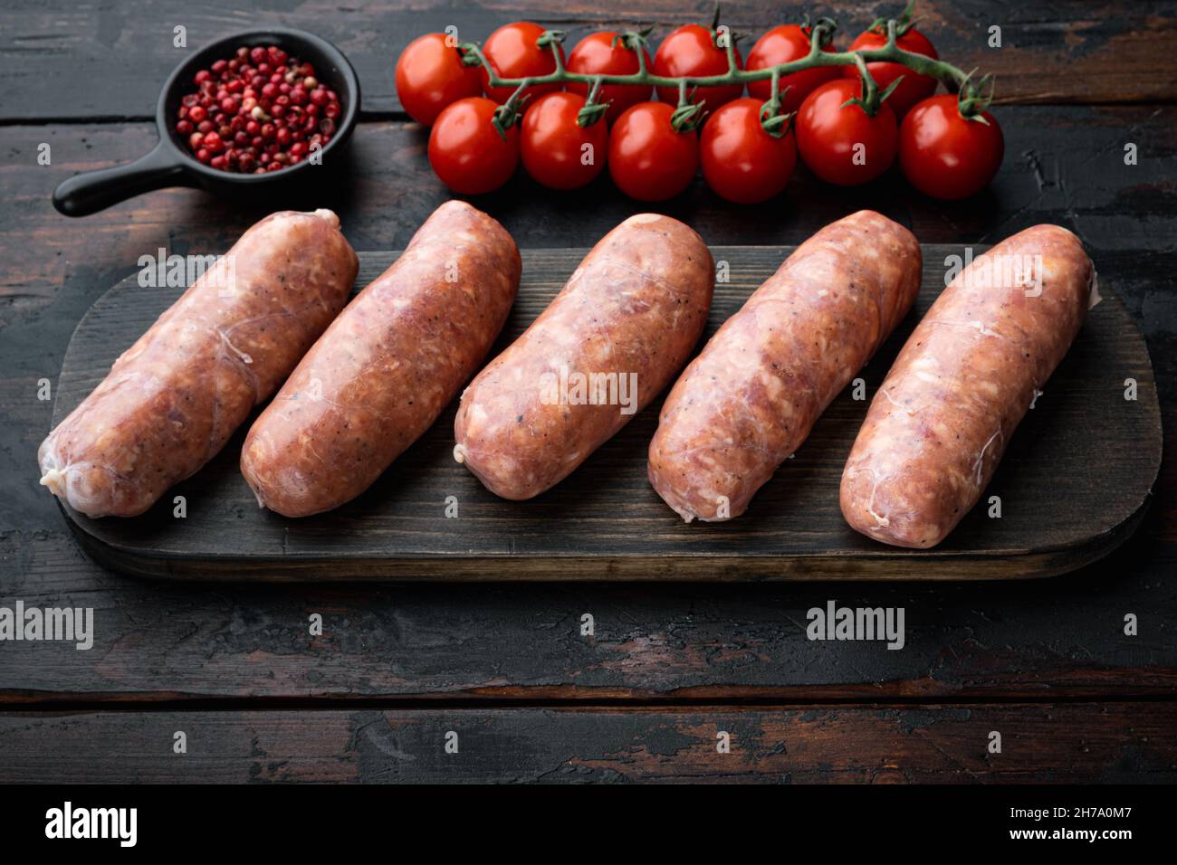 Traditional pork sausages, on old dark wooden background. Stock Photo