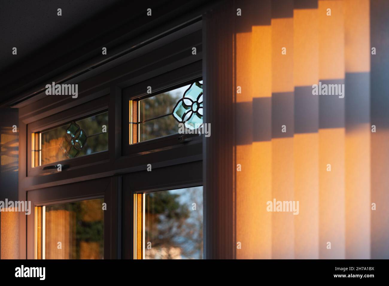 Shallow focus on golden sunlight catching the frame of a window in a