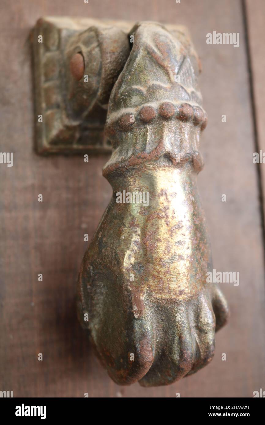 Antique brass door knocker in the shape of a hand Stock Photo