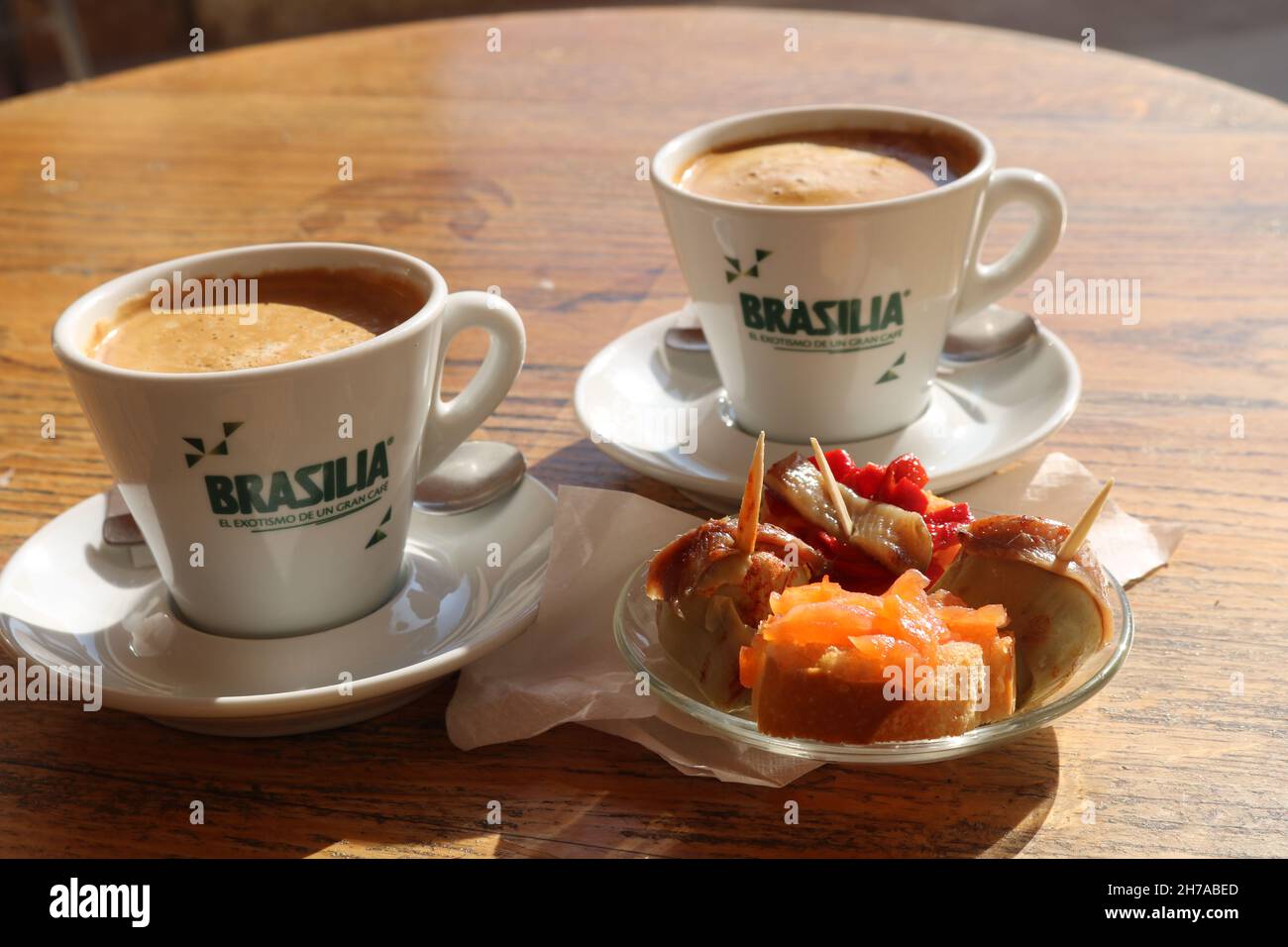 Two cups of strong  black coffee Brasilia and a plate of tapas in the sunshine Stock Photo