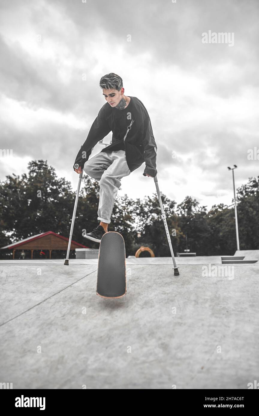 Guy with crutches on skateboard doing trick on ramp Stock Photo Alamy