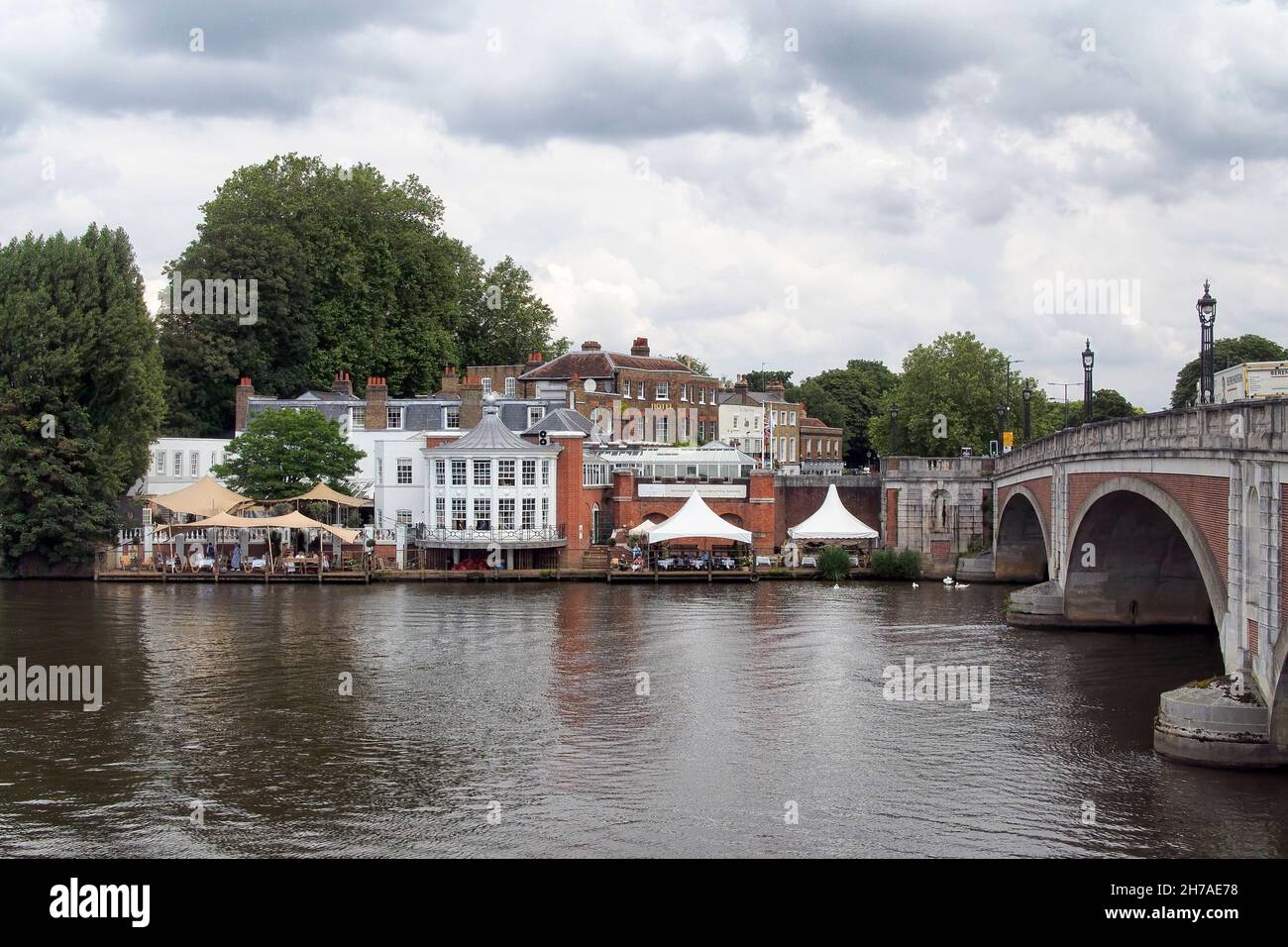 MOLESEY, SURREY, UK - JULY 09, 2021:  View across the River Thames of Hampton Court bridge and the Mitre Hotel in East Molesey Stock Photo