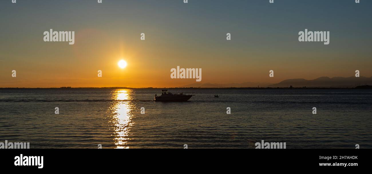 Sailing boat in the sunset. Boat in the ocean at beautiful sunset. Stock Photo