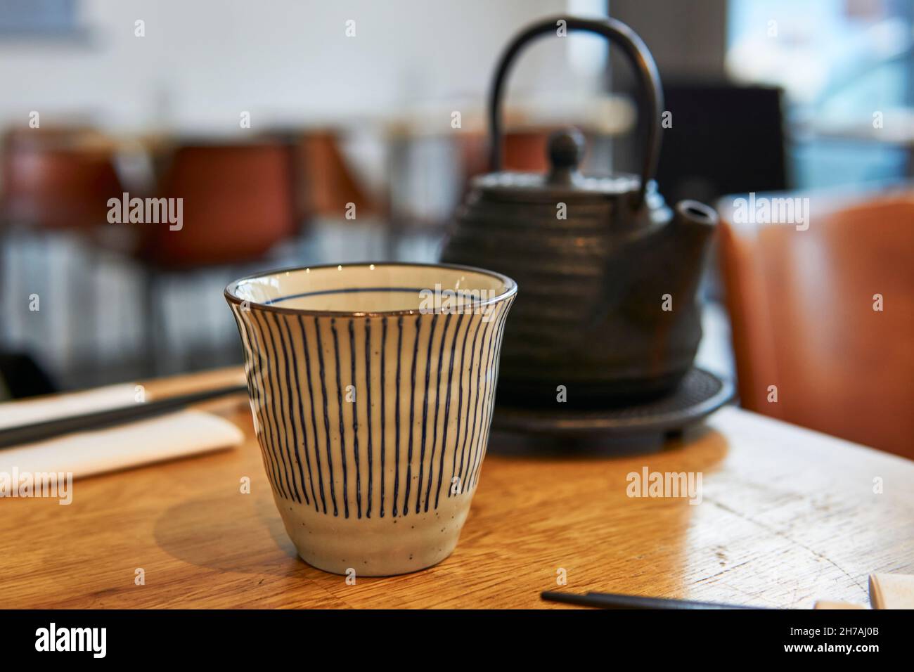 Asian teapot and cup on a restaurant table. Black teapot Stock Photo