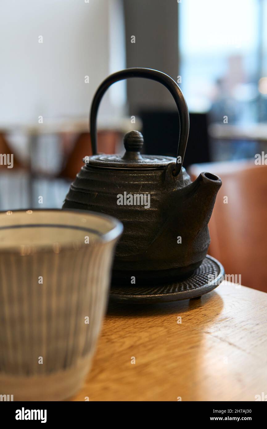 Asian teapot and cup on a restaurant table. Black teapot Stock Photo