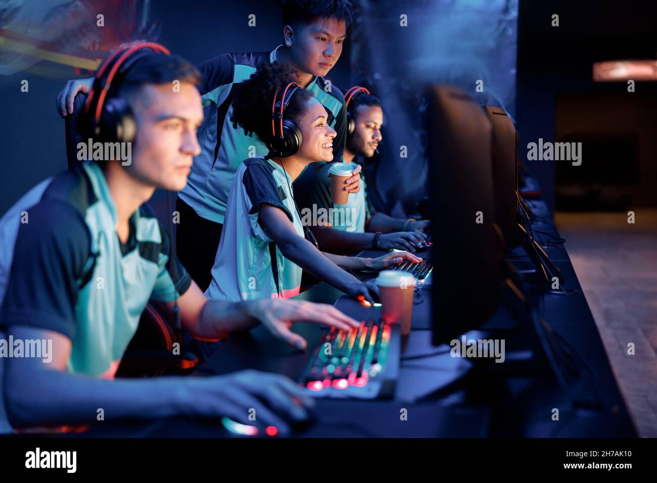 Young gamers in headsets playing in video game club Stock Photo