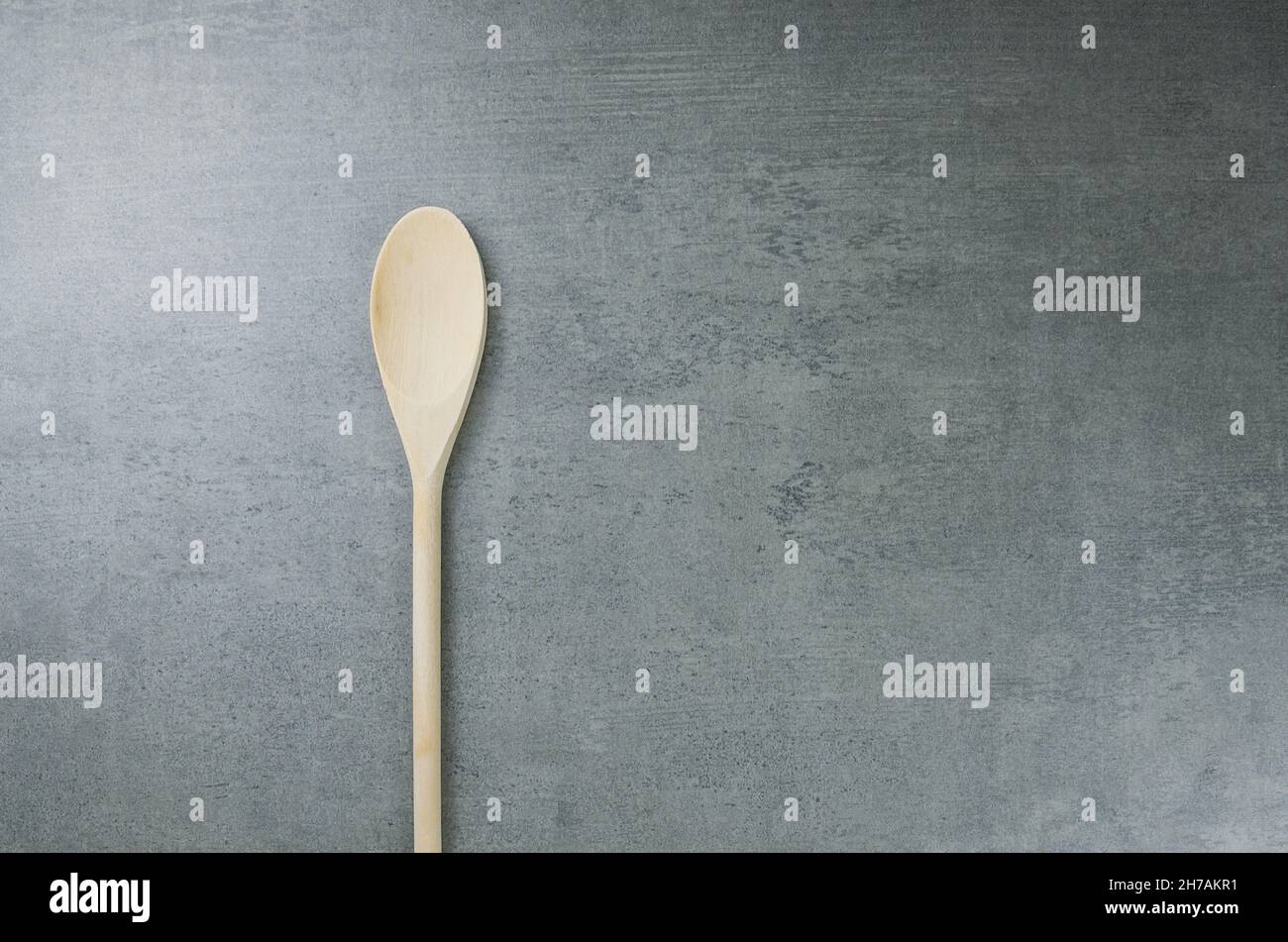 Empty wooden spoon on gray concrete background. Stock Photo