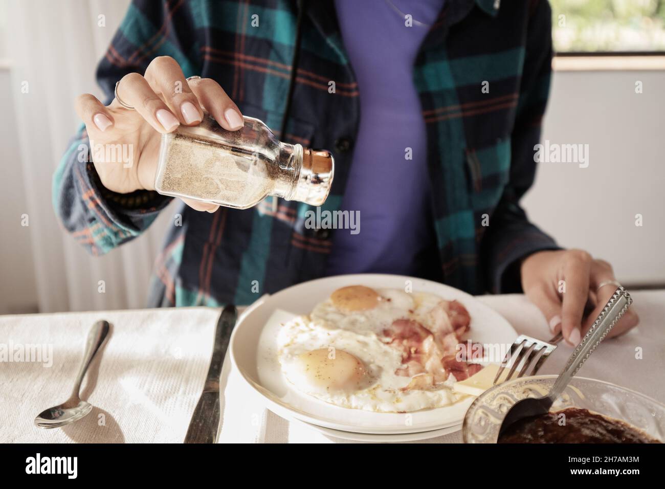 Add a spicy pepper seasoning to a dish with fried eggs and pork