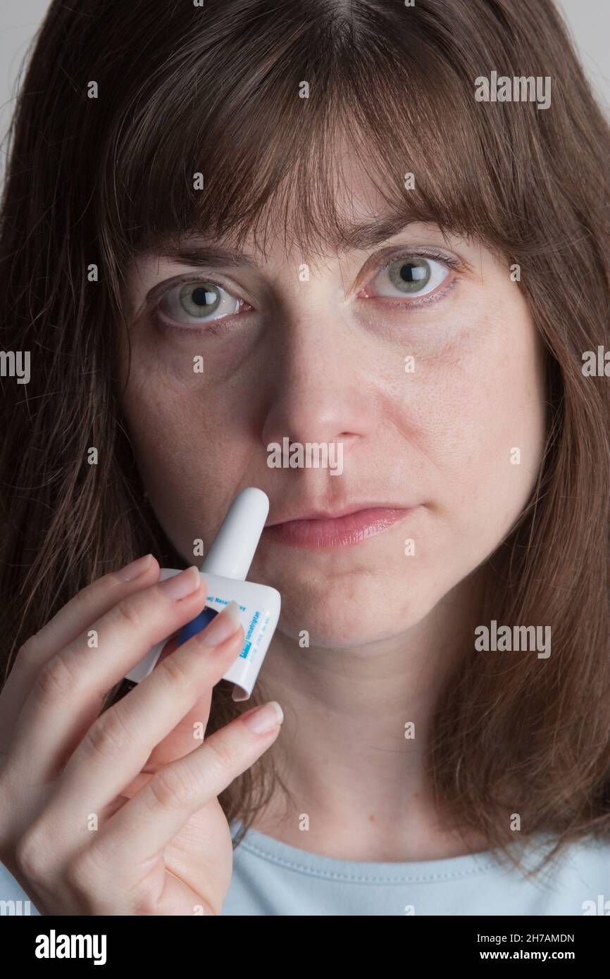 Young woman using Imitrex inhaler for migraine. Stock Photo