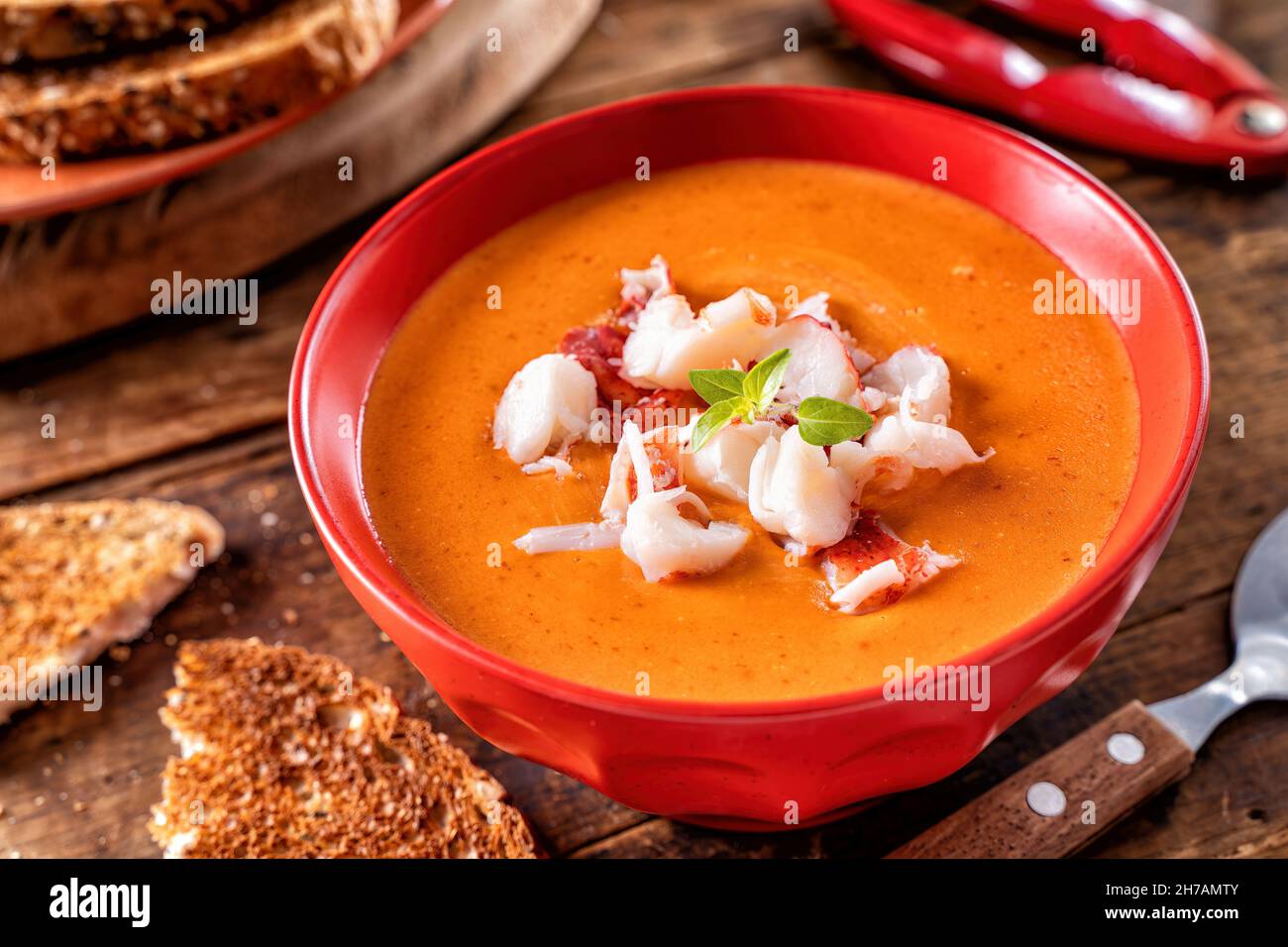 A bowl of delicious creamy lobster bisque with lobster meat, tomato paste, cream and cognac. Stock Photo