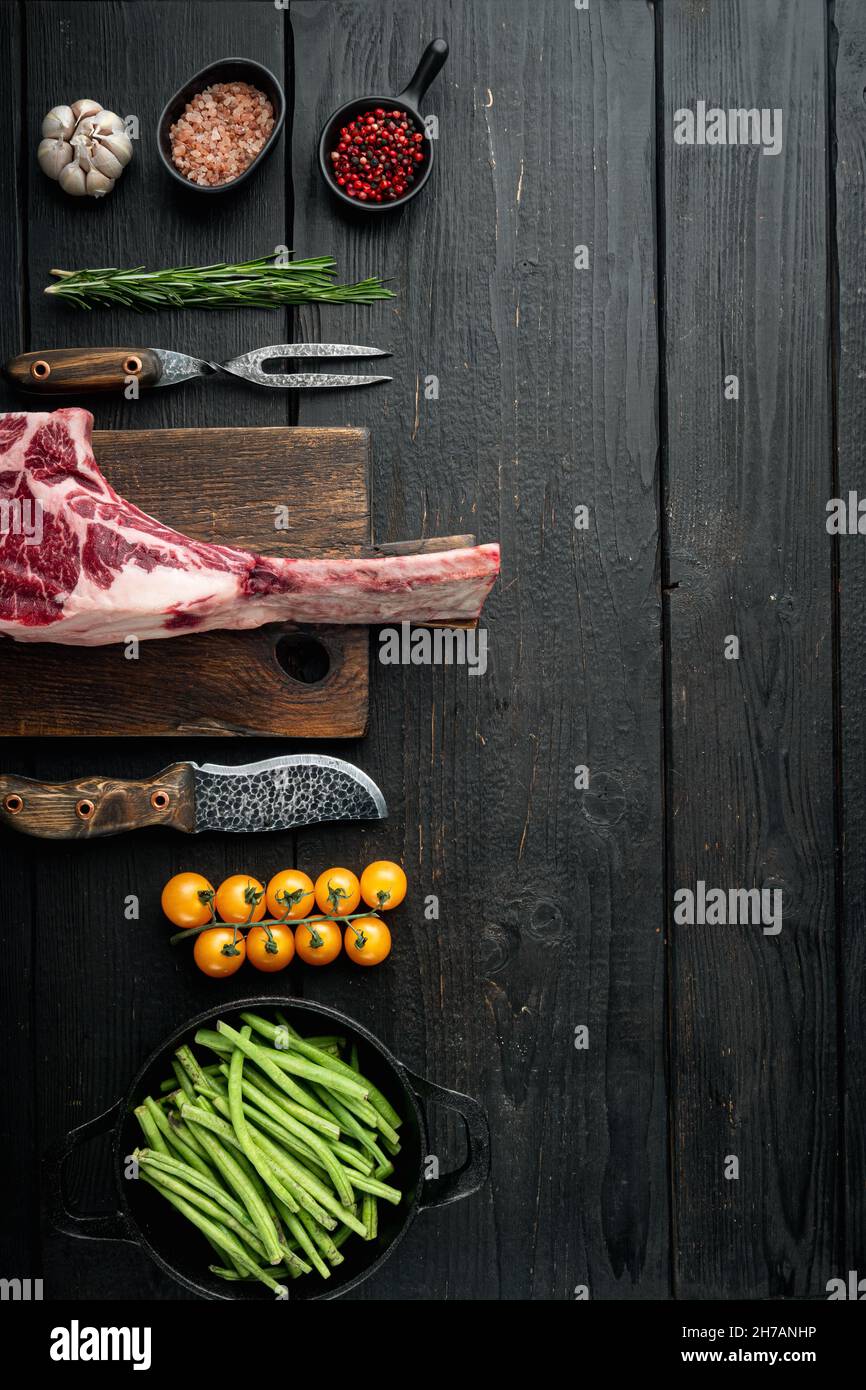 Cooking meat background. Raw tomahawk steak, with spices and herbs for ...