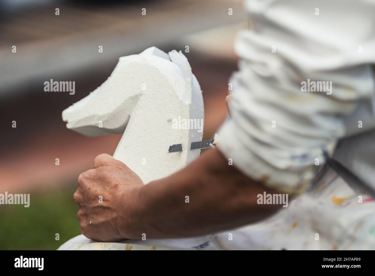 Person making a figure of a horse from a piece of polystyrene Stock Photo