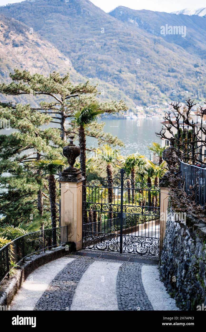 Gate at the entrance to Villa Balbianello with mountains in the background. Lake Como, Italy Stock Photo