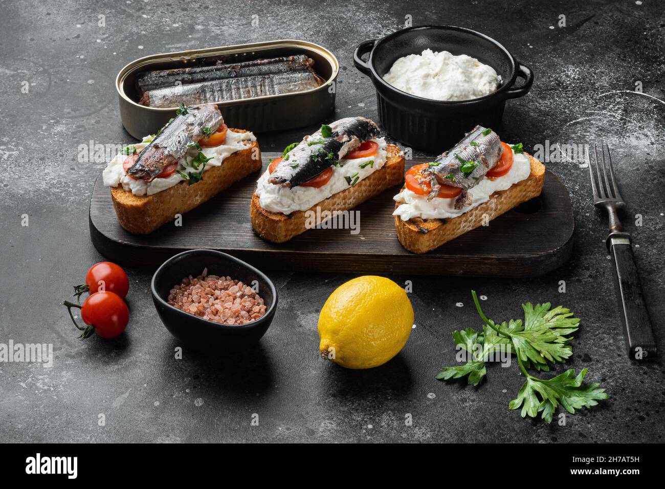 Sardines sandwich with smoked fish set, on black dark stone table ...