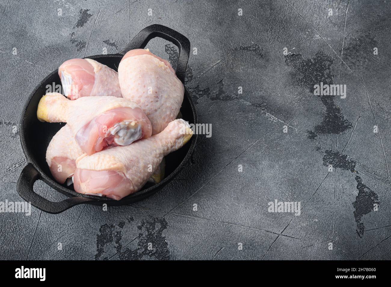 Chicken brow and drumstick with skin set, in frying cast iron pan, on
