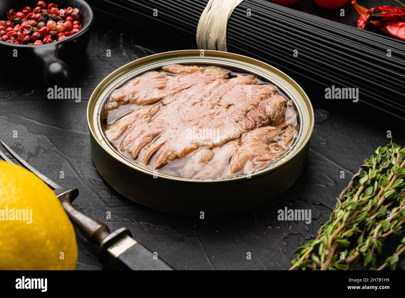 Tuna canned fish seafood set, on black dark stone table background ...