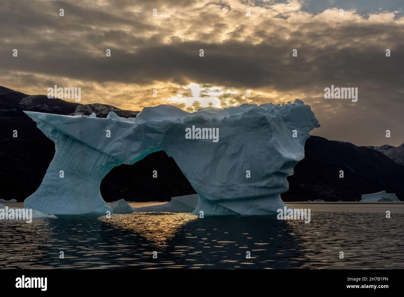 Iceberg arch at sunset, Rypefjord, Scoresby Sund, Greenland Stock Photo