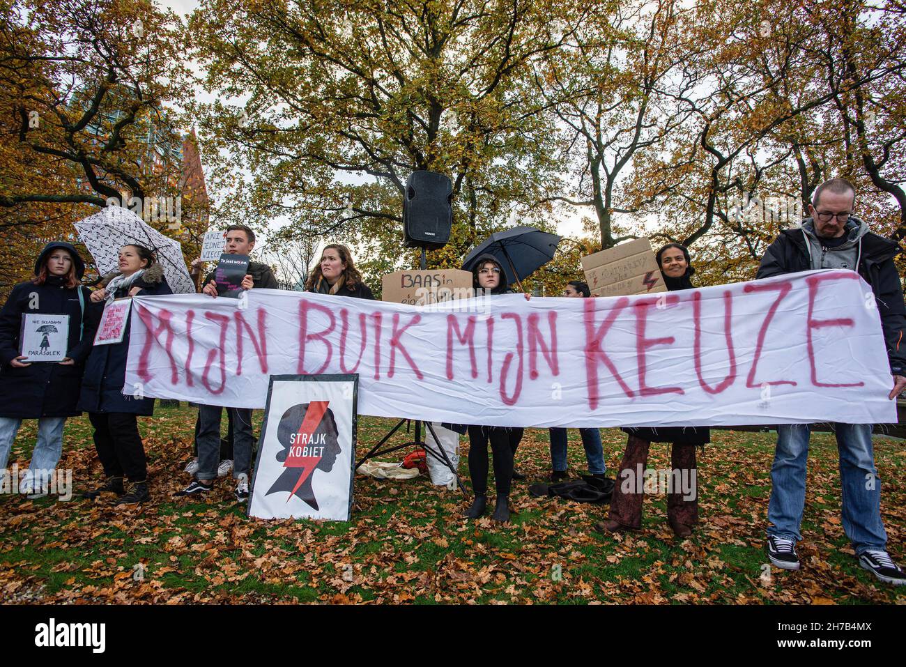 Protesters hold a banner and placards during the demonstration.A small group of protesters assembled at the Koekamp, in The Hague. denouncing Poland's new anti-abortion law, and to remember its known victim Iza, 30-year-old, a would be mother with no medical complications, died in September due to septic shock. Hospital doctors in Pszczyna, Southern Poland, would not terminate her 22-week pregnancy, even though the fetus had no chance of survival. Doctors now have to wait for the fetus to die in a natural way before an abortion is performed. Women's rights activists say the woman was a victim Stock Photo