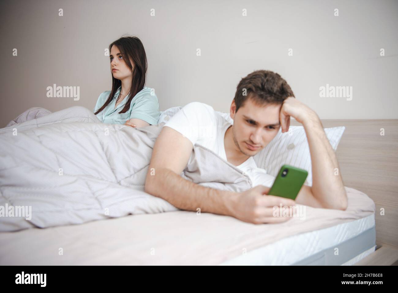 Couple Lying In Bed Young Wife Sitting With Feeling Upset Her Husband