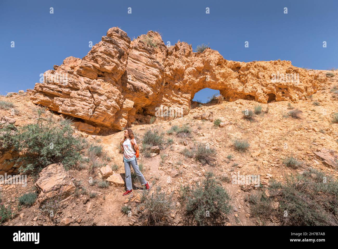 Tourist woman with backpack walks along a trail in a deserted canyon