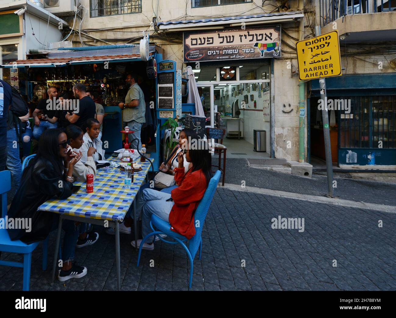 Young Israeli women of Ethiopian race smoking hookah at the Mahane Yehuda market in Jerusalem, Israel. Stock Photo