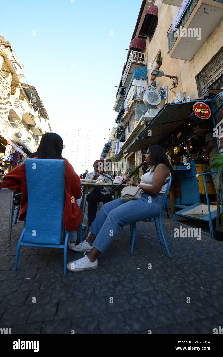 Young Israeli women of Ethiopian race smoking hookah at the Mahane Yehuda market in Jerusalem, Israel. Stock Photo
