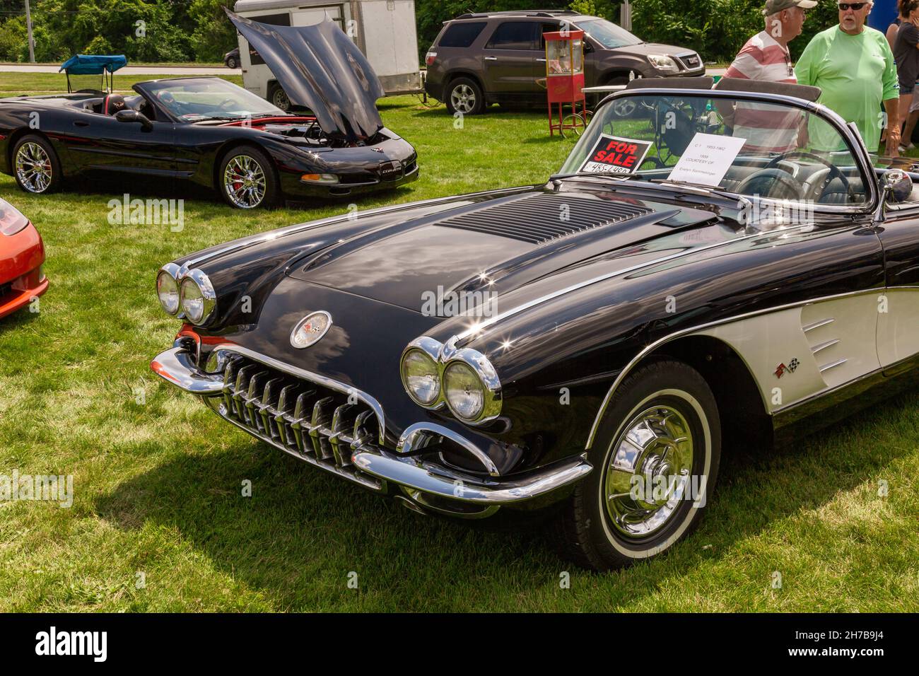 A black 1958 Chevrolet C1 Corvette convertible advertised for sale contrasts with the C5 Corvette at a car show in Fort Wayne, Indiana, USA. Stock Photo