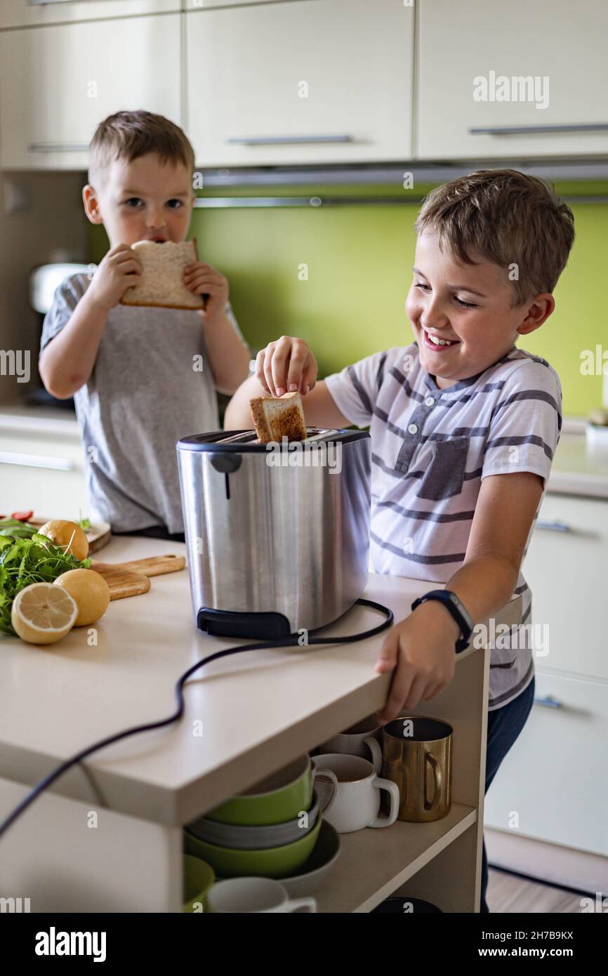 Two funny little brothers cooking and eating together fresh frying