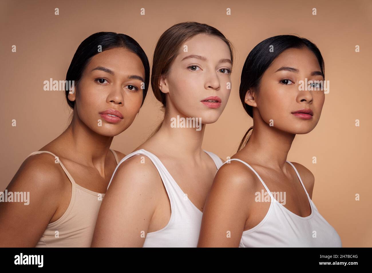 Caucasian, african-american and asian young women posing together for camera Stock Photo