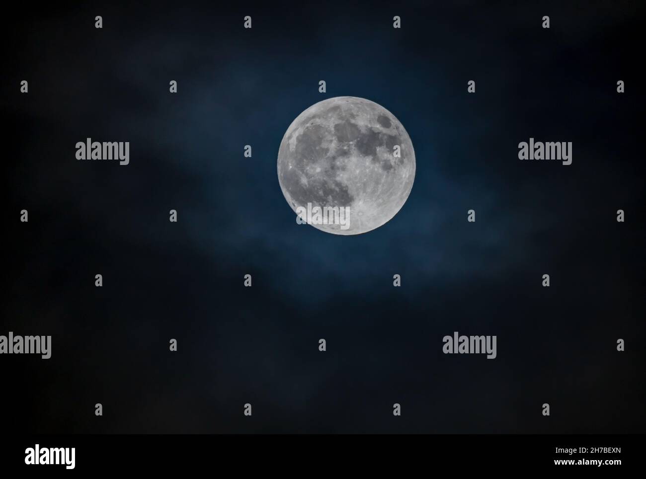 Full moon against the black cloudy night sky Stock Photo