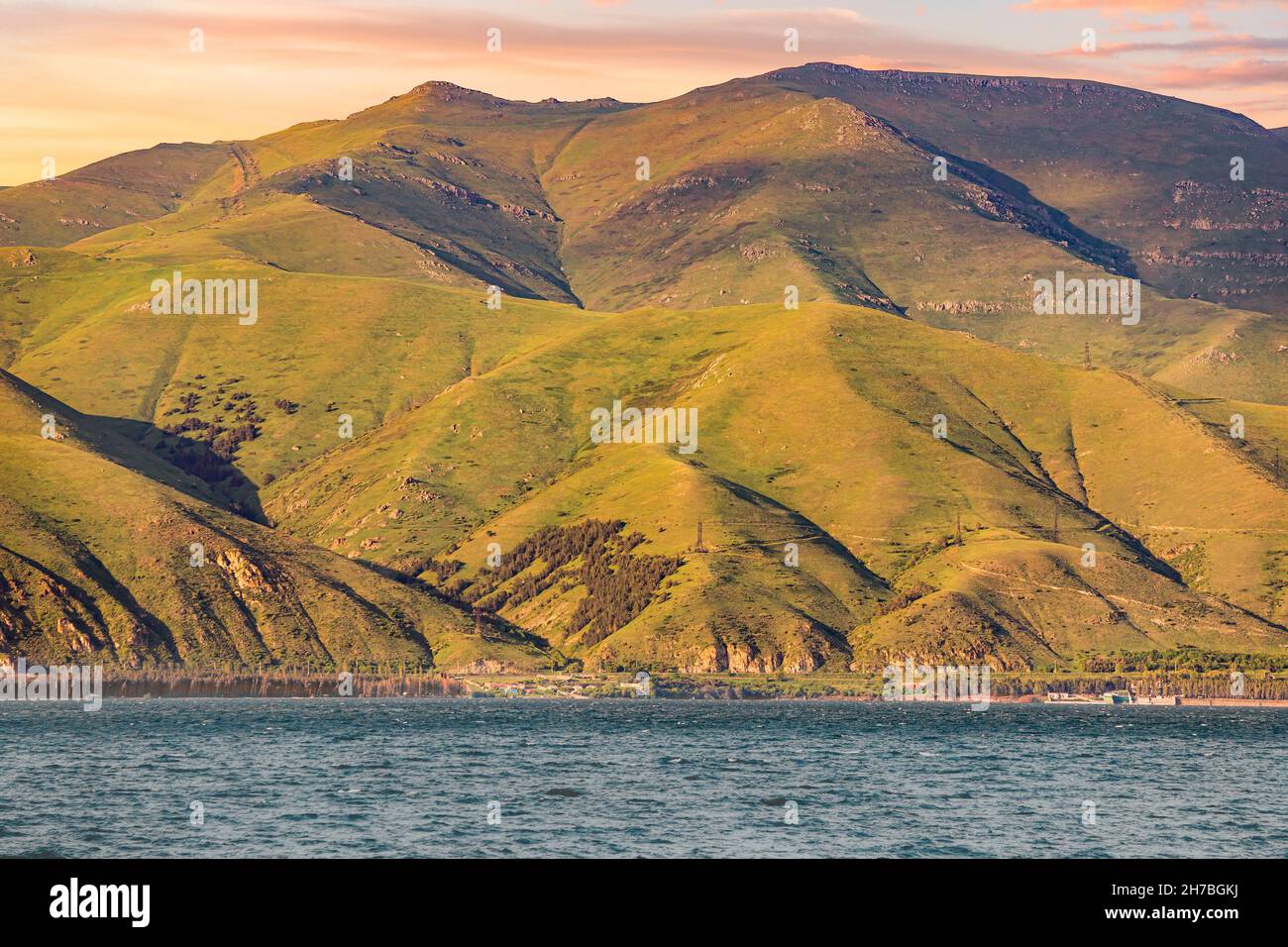 Sevan lake with bald mountain ranges. Dramatic and harsh northern landscape. Tourist attractions and ecology Stock Photo