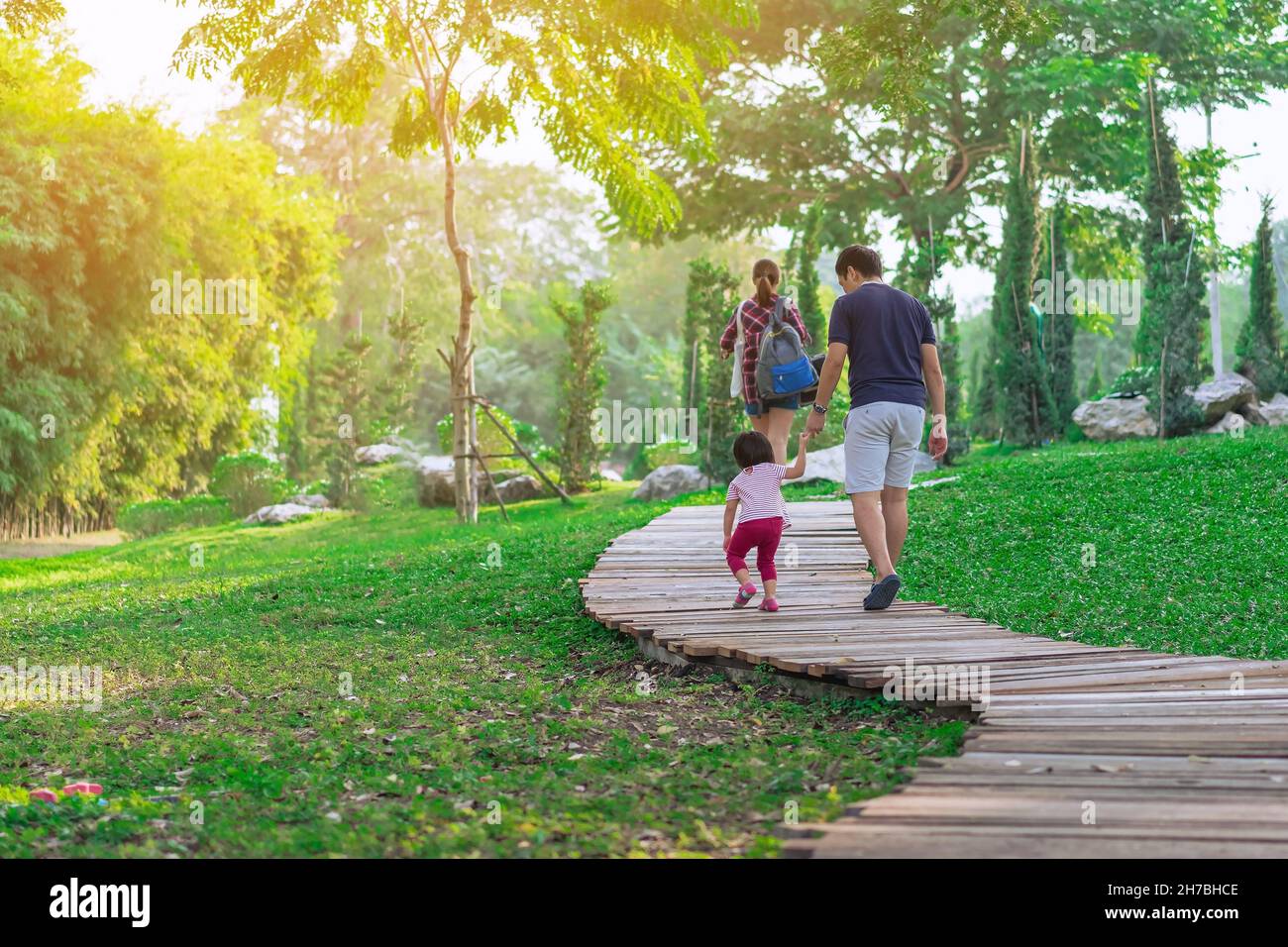 Back view of Asian Father hand holding lovely daughter walking on ...