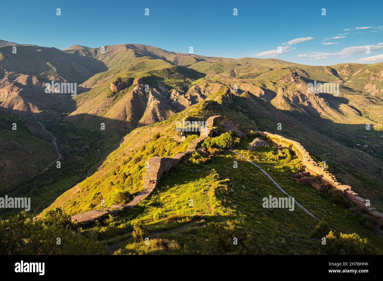Panoramic view of the famous Smbataberd fortress in the Armenian Transcaucasia with gorgeous views of mountain valleys at golden sunset light Stock Photo