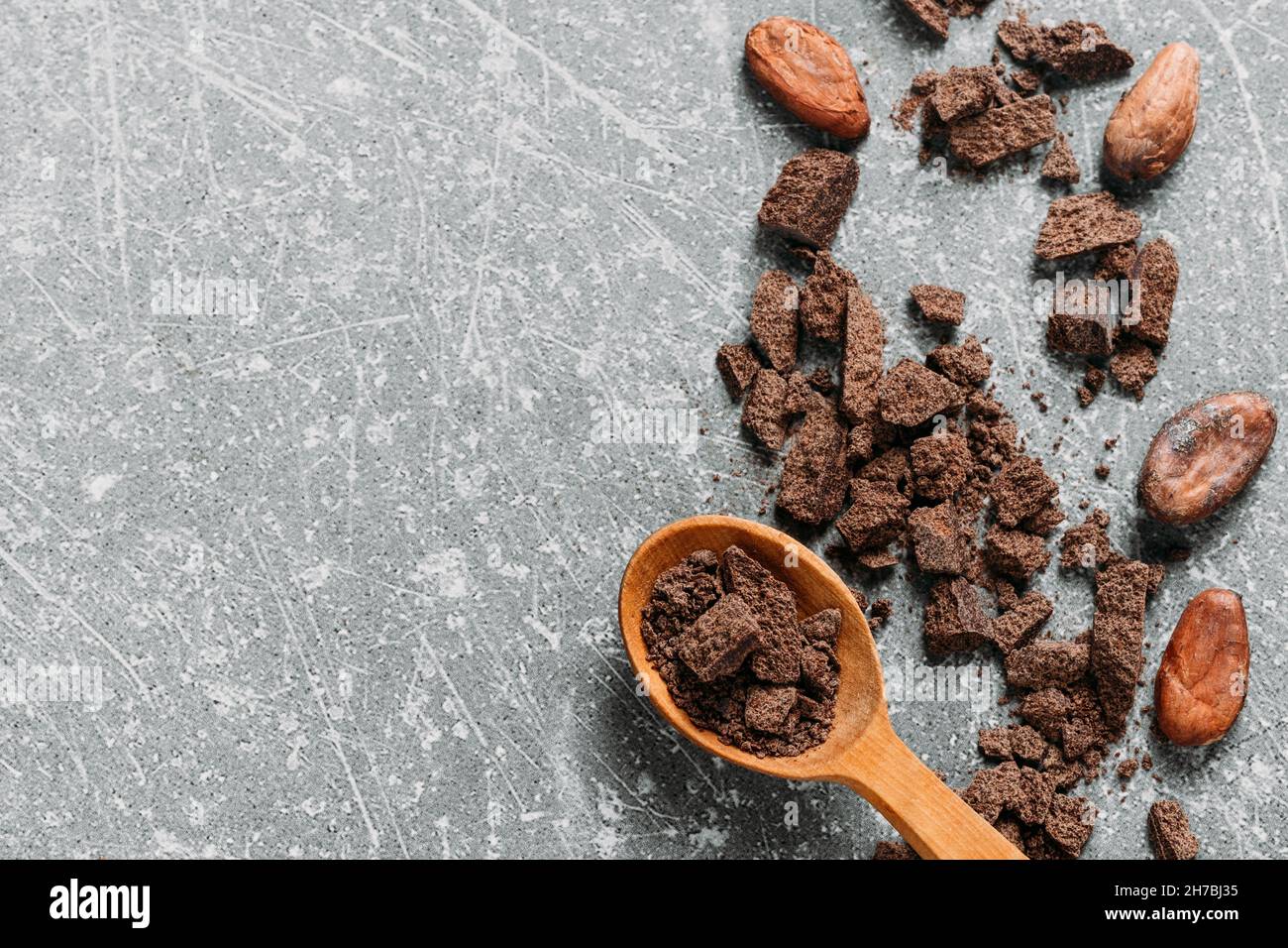 Cacao beans on grey concrete background. Raw fermented. organic cocoa seeds for hot chocolate drink. Flat lay, copy space for food and drink recipe Stock Photo